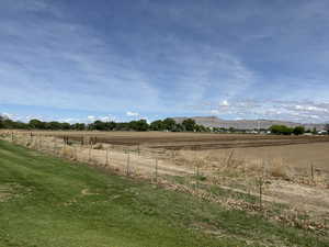 View of yard featuring fence, a rural view, and a mountain view
