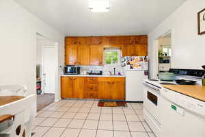 Back Unit's Kitchen featuring white appliances, brown cabinets, light countertops, and a sink