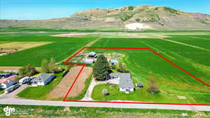 Boundaries shown are approximate, survey stakes are on the property corners. Overview of rural landscape featuring property parcel outlined and mountains