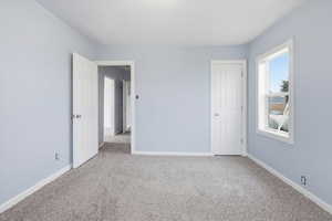 Unfurnished bedroom with carpet and baseboards