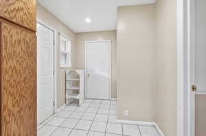 Corridor with baseboards and light tile patterned floors