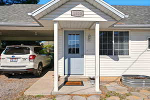 Back Unit's Entrance to property featuring a shingled roof and an attached carport