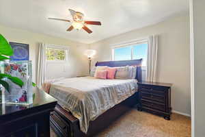 Back Unit's Bedroom with light carpet, baseboards, and ceiling fan