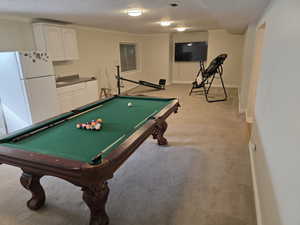 Game room with a textured ceiling, billiards table, light carpet, baseboards, and crown molding