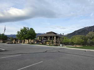 View of asphalt street featuring a mountain view, curbs, and street lighting