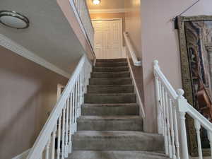 Stairway featuring crown molding