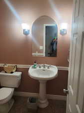 Half bathroom with baseboards and toilet