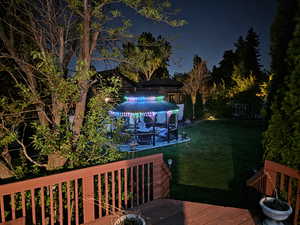 Deck at night with a lawn and a gazebo