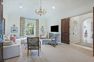 Living room with a chandelier, arched walkways, high vaulted ceiling, recessed lighting, and baseboards