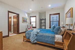 Carpeted bedroom with baseboards, recessed lighting, and connected bathroom