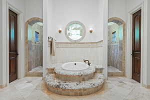 Bathroom with a whirlpool tub, a walk in shower, marble finish flooring, and baseboards