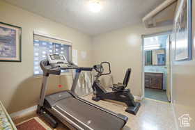 Workout area with a textured ceiling and baseboards