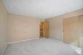 Empty room featuring light colored carpet and baseboards