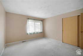 Carpeted empty room featuring baseboards