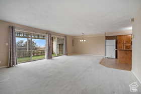 Unfurnished living room with baseboards and light colored carpet