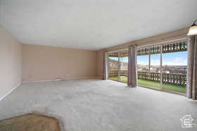 Unfurnished living room with carpet floors and baseboards