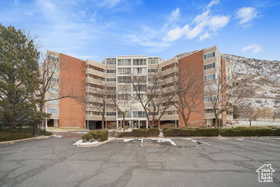 View of apartment building / complex featuring uncovered parking