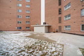 Snow covered building featuring a view of apartment building / complex