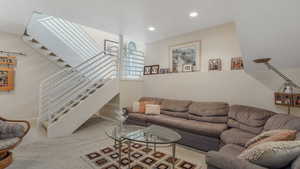 Carpeted living room featuring stairway, recessed lighting, and baseboards