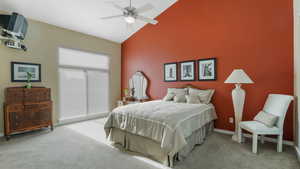 Bedroom with light colored carpet, high vaulted ceiling, baseboards, and a ceiling fan