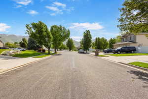 View of asphalt street featuring a mountain view and curbs