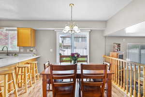 Dining room featuring light wood-style flooring, a chandelier, and plenty of natural light