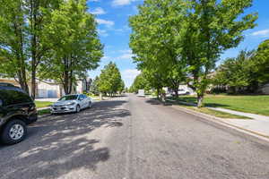 View of asphalt road featuring sidewalks, a residential view, and curbs