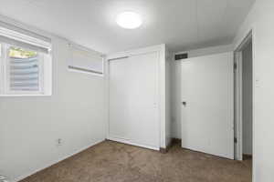 Unfurnished bedroom featuring carpet and a closet