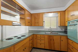 Kitchen featuring a sink, white electric stovetop, open shelves, wall oven, and stainless steel microwave