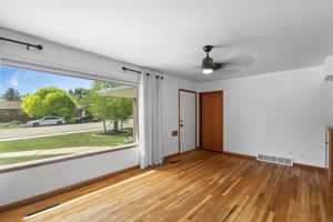 Foyer entrance featuring light wood-style floors, ceiling fan, and baseboards