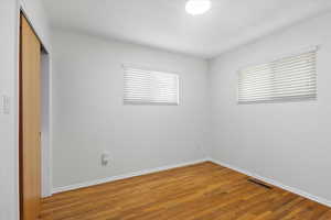 Unfurnished bedroom featuring a closet, light wood-type flooring, and baseboards