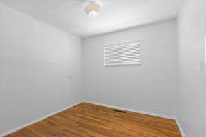 Spare room featuring baseboards and wood finished floors