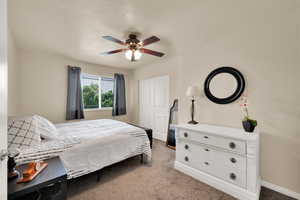 Bedroom featuring carpet floors, baseboards, and ceiling fan