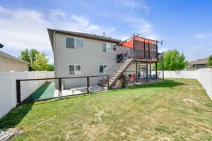 Back of house with stairs, a deck, a patio area, and a gate