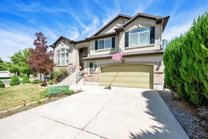 View of front of house with stucco siding, a garage, concrete driveway, and a front yard