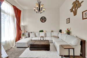 Living area featuring carpet and a chandelier