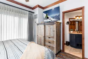 Bedroom featuring crown molding, wood finished floors, and a sink