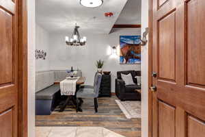 Dining space featuring wood finished floors, a chandelier, breakfast area, a textured wall, and a textured ceiling