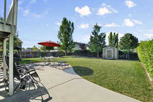 View of yard featuring a storage unit, a patio, an outdoor structure, and stairway