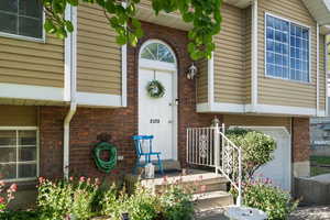 Property entrance with brick siding and a garage
