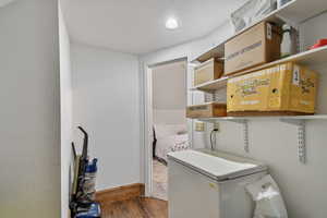 Clothes washing area with wood finished floors, baseboards, and recessed lighting