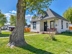 View of front of house featuring covered porch, a shingled roof, and cooling unit