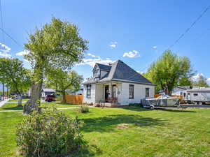Rear view of house with a yard and roof with shingles