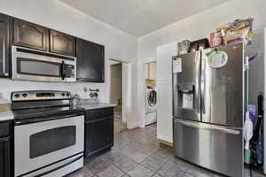 Kitchen with appliances with stainless steel finishes, a sink, pendant lighting, and light countertops