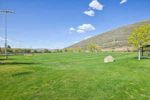 View of property's community with a mountain view and a lawn