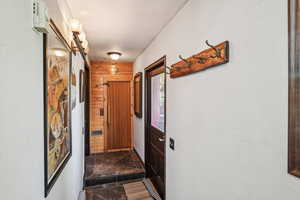 Hall with dark stone finish floors and wooden walls