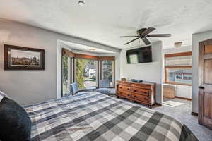 Carpeted bedroom with baseboards, a textured ceiling, and ceiling fan