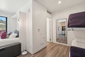 Corridor with wood finished floors, recessed lighting, and baseboards