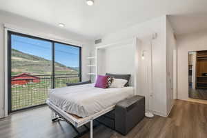 Bedroom featuring wood finished floors, baseboards, and access to outside