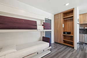 Bedroom featuring dark wood-style flooring, a sink, and baseboards